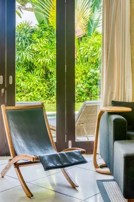 a chair sitting in a room with a window at Virginia villa 4BR 5min walk to beach with assistant villa and pick up from airport and security in Canggu