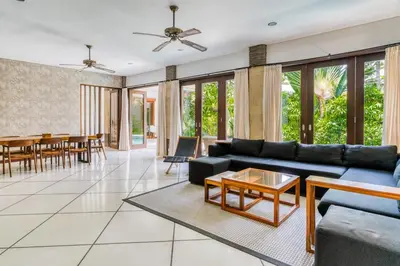 a living room with a couch and a table at Virginia villa 4BR 5min walk to beach with assistant villa and pick up from airport and security in Canggu