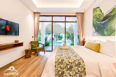 a bedroom with a large bed and a tv at Villa Marlex by Bukit Vista in Seminyak