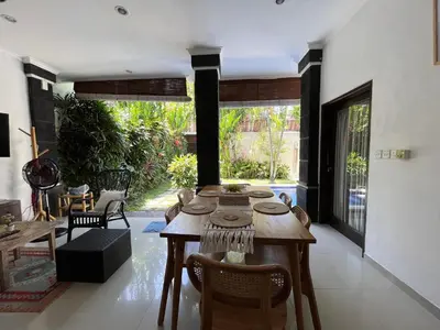 a dining room with a wooden table and chairs at Kubu D Kubu Villa - 3 Bedroom - Legian in Legian