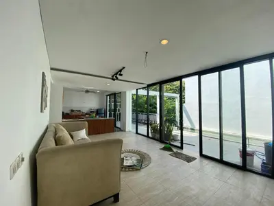 a living room with a couch and large windows at 3 BR Chrysanthemum Villa nusadua in Nusa Dua