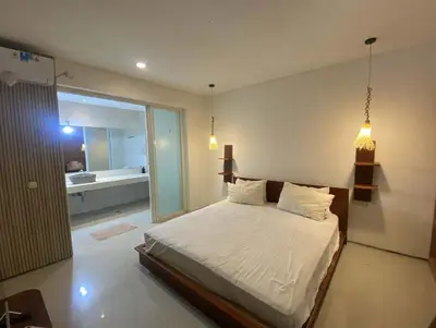 a bedroom with a large bed and a bathroom at 3 BR Chrysanthemum Villa nusadua in Nusa Dua