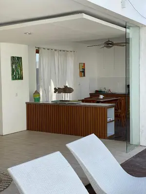 a living room with two white chairs and a kitchen at 3 BR Chrysanthemum Villa nusadua in Nusa Dua