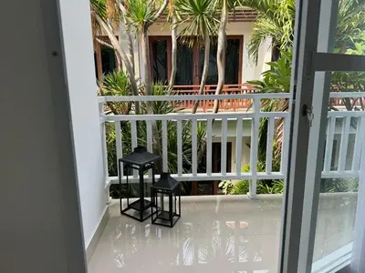 two black stools on a balcony with palm trees at HomelyBali, Cozy studio in Rajapala! in Seminyak