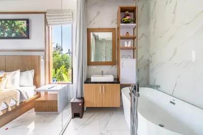 a bathroom with a tub and a sink and a bed at Villa Sun Lila by JB Villas in Seminyak