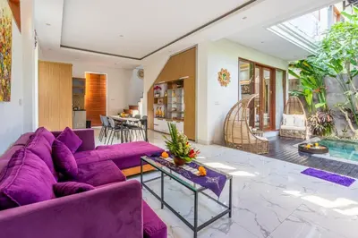 a living room with a purple couch and a table at Villa Sun Lila by JB Villas in Seminyak