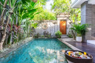 a swimming pool in the middle of a garden at Villa Sun Lila by JB Villas in Seminyak