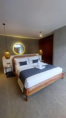 a bedroom with a large bed and a mirror at Akhila 1 - 1 BR modern tropical villa at the heart of Seminyak in Seminyak