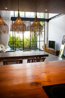 a dining room with a table and chairs and lights at Tropical Loft Steps Away from the Beach! Hidden GEM! in Canggu