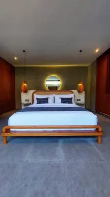 a bedroom with a large bed and two lamps at Akhila 5 - 1 BR modern tropical villa at the heart of Seminyak in Seminyak