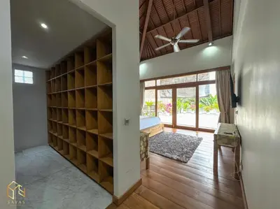 a room with a large closet with wooden shelves at Tranquil Classic Balinese Villa in Badung