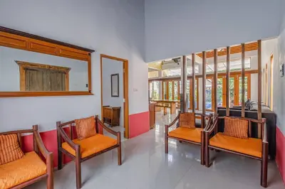a room with chairs and a table and windows at Private 3 Bedroom Villas, 5 mnt to Beach Nusa Dua in Nusa Dua