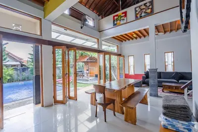 a dining room with a table and a couch at Private 3 Bedroom Villas, 5 mnt to Beach Nusa Dua in Nusa Dua