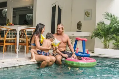 a man and two women and a child sitting in a swimming pool at Seminyak Villa, Pool, 2 min to Double Six Beach in Seminyak