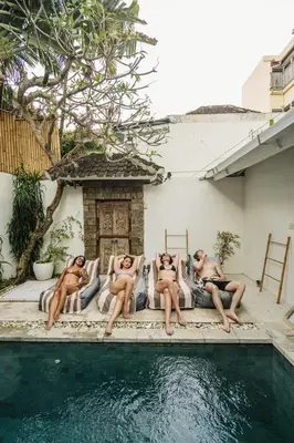 four naked men laying on beds next to a swimming pool at Seminyak Villa, Pool, 2 min to Double Six Beach in Seminyak