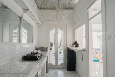 a kitchen with white walls and windows and a stove at Seminyak Villa, Pool, 2 min to Double Six Beach in Seminyak