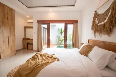 a bedroom with a white bed and a large window at Sundaze 1 - Private Vila in Canggu with Huge Pool in Kerobokan