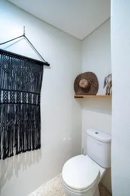 a bathroom with a toilet and a black shower curtain at Anggana Villa 2 in Canggu