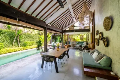 a living room with a wooden table and a pool at Anggana Villa 2 in Canggu