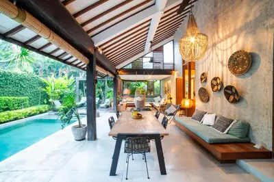an outdoor living room with a table and a pool at Anggana Villa 2 in Canggu