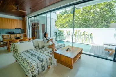 a woman sitting on a couch in a living room at Pradha Kuta, 3 BDR, 3 minutes from seminyak beach in Seminyak