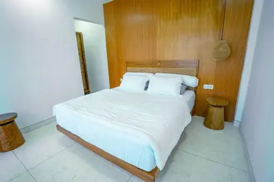 a bed with white sheets and pillows in a bedroom at Pradha Kuta, 3 BDR, 3 minutes from seminyak beach in Seminyak