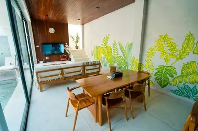 a living room with a wooden table and a tv at Pradha Kuta, 3 BDR, 3 minutes from seminyak beach in Seminyak