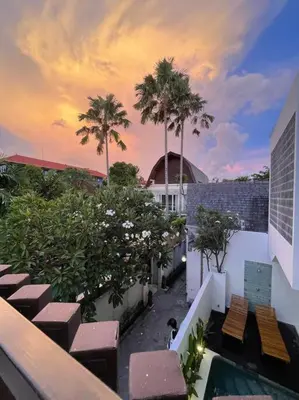 a view of a balcony of a building with palm trees at Pradha Kuta, 3 BDR, 3 minutes from seminyak beach in Seminyak
