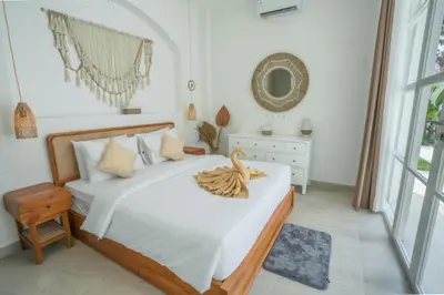 a bedroom with a large bed with a wooden frame at Stunning tropical 3bed Villa in Canggu