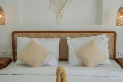 a bed with white pillows and a wooden headboard at Stunning tropical 3bed Villa in Canggu