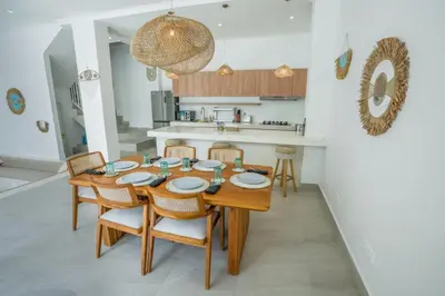 a kitchen and dining room with a wooden table and chairs at Stunning tropical 3bed Villa in Canggu