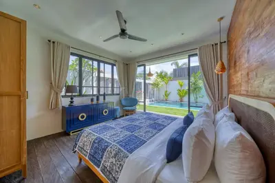 a bedroom with a bed and a large window at Chic Tranquility Modern yet Timeless 3BD Villa in Canggu