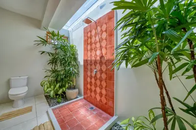 a bathroom with a shower with plants and a toilet at Chic Tranquility Modern yet Timeless 3BD Villa in Canggu
