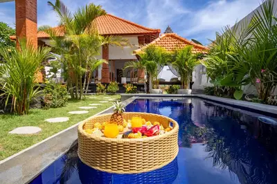 a basket of fruit sitting next to a swimming pool at Viewbali 1 - Villa with Jungle Garden Big Pool and Kitchen in Kerobokan