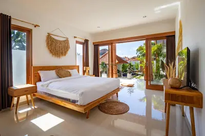 a bedroom with a bed and a large window at Viewbali 1 - Villa with Jungle Garden Big Pool and Kitchen in Kerobokan
