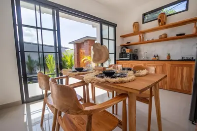 a kitchen with a wooden table and chairs at Viewbali 1 - Villa with Jungle Garden Big Pool and Kitchen in Kerobokan