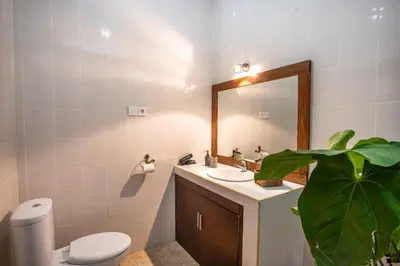 a bathroom with a sink and a toilet and a mirror at Villa Shiro in Seminyak