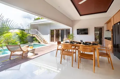 an open kitchen and dining room with a table and chairs at Sunterra Villa with Ricefield View in Canggu in Kerobokan