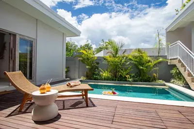 a patio with a pool and a chair and a table at Sunterra Villa with Ricefield View in Canggu in Kerobokan