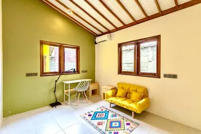 a living room with a yellow couch and a table at Mantra Dom Villa 3 Bedrooms in Canggu