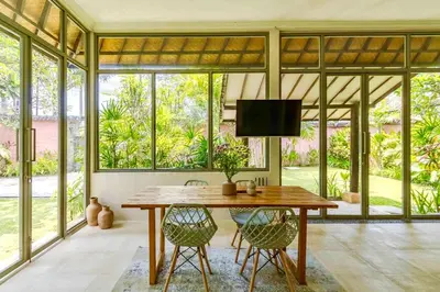 a dining room with a wooden table and chairs at Mantra Dom Villa 3 Bedrooms in Canggu