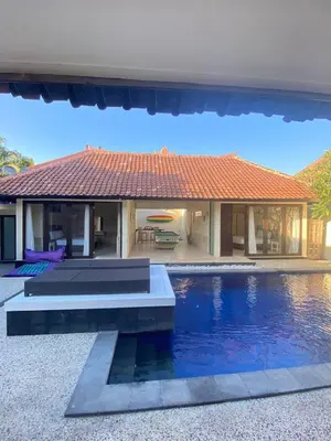 a house with a swimming pool in front of it at Sorry we close in Seminyak