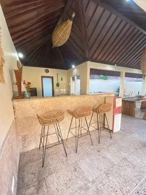 a kitchen with a bar with chairs and a counter at Sorry we close in Seminyak