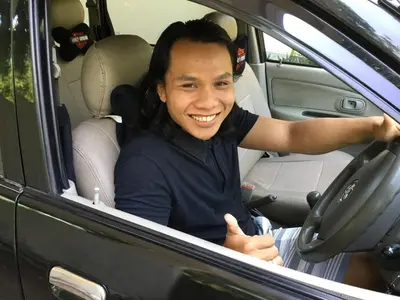 a man sitting in a car giving a thumbs up at Seminyak Villa in Seminyak