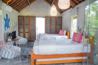 a bedroom with two beds and a tv in it at Villa Marie Clare in Seminyak
