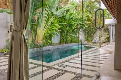 a pool in the middle of a house with plants at Villa Marie Clare in Seminyak