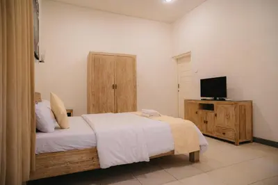 a bedroom with a bed and a flat screen tv at Adijaya Rooms in Seminyak