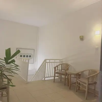 a room with a table and chairs and a staircase at Adijaya Rooms in Seminyak