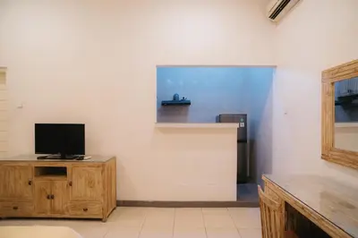 a living room with a tv on a wooden cabinet at Adijaya Rooms in Seminyak