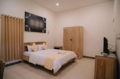a bedroom with a bed and a television in it at Adijaya Rooms in Seminyak